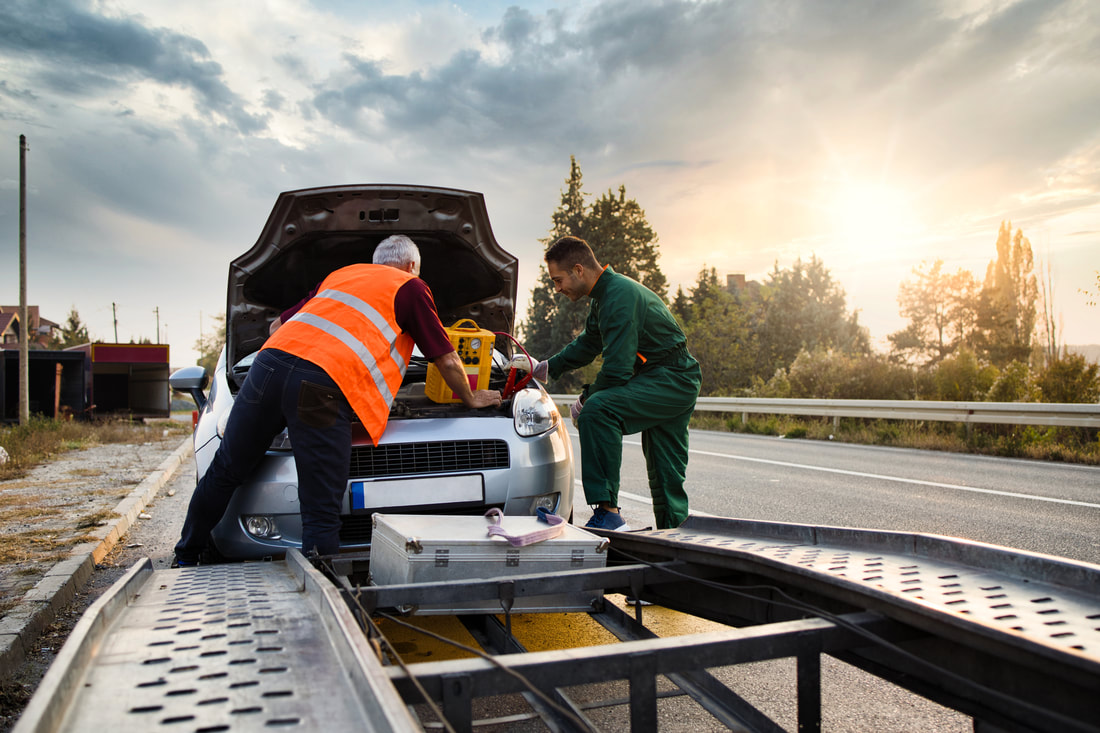 Roadside technicians preparing a disabled vehicle for towing